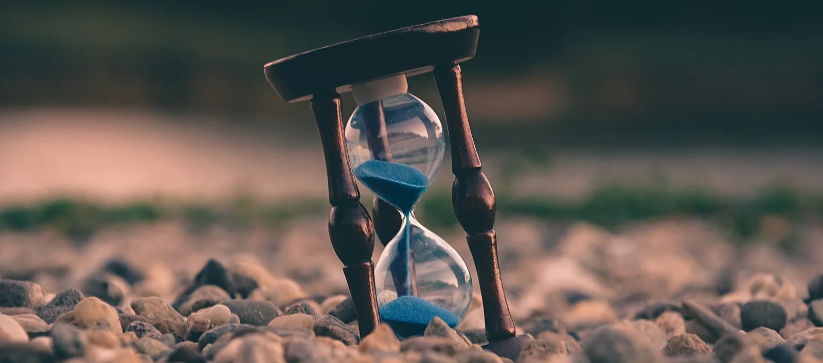 An hourglass sitting on some rocks