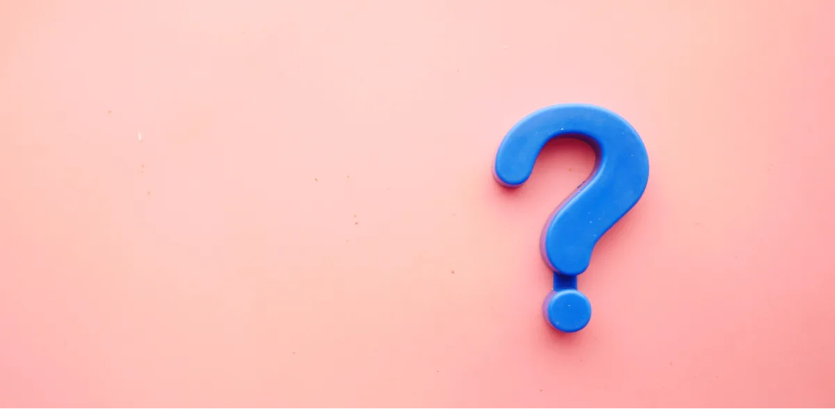 A blue question mark on a pink background.