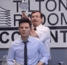 Ben from Parks and Recreation thinking at a desk, then someone holds a lightbulb over his head and turns it on. Ben gestures as though he has just figured something out.