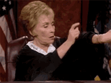 Judge Judy pointing at her watch.